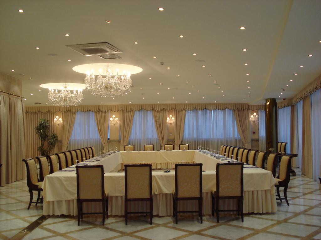 Hotel Alameda Palace Salamanca Kültér fotó The photo shows a spacious and elegantly designed conference room. The room features a large rectangular table surrounded by numerous chairs, all arranged for a meeting or discussion. The table is covered with a white tablecloth, and the walls are ad